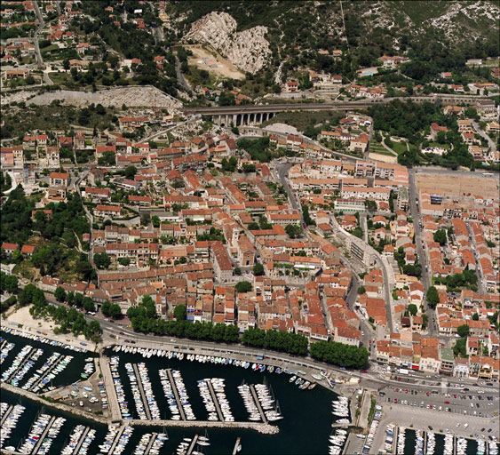 Vue aérienne du quartier de l'Estaque-Eglise ou Estaque-Plage (1978 Estaque K ; 1978 Estaque L), prise du sud en direction du nord ; au premier plan le port et la voie littorale dite Plage (RN 568b), à l'arrière-plan la voie ferrée et le viaduc du Marinier. Le quartier est délimité à gauche par la traverse Mistral longeant le jardin de la villa Mistral et à droite par le boulevard Roger-Chieusse.