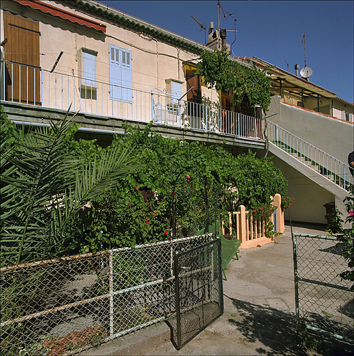 Vue prise de la cour sur l'escalier extérieur et la coursière.