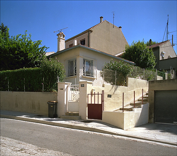 Maison, 19 boulevard Baudin, parcelle K 67, construite en 1953. Vue générale rapprochée (angle sud-ouest) prise du boulevard Baudin, clôture et jardin au premier plan.