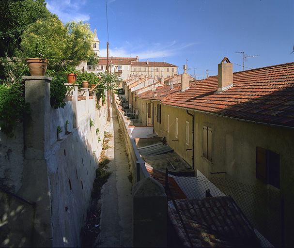 Vue des façades nord avec les courettes en contrebas de la traverse du Lion, prise depuis la traverse Mistral en direction de l'église.
