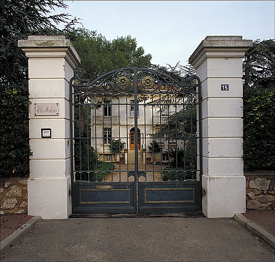 Vue d'ensemble de la façade ouest avec portail au premier plan de la Villa Malou.