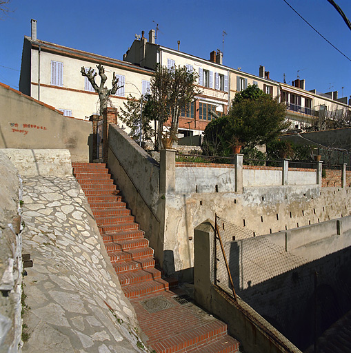 Vue générale des façades sud et des jardins surplombant la traverse du Lion, prise depuis le bas de la traverse Mistral.