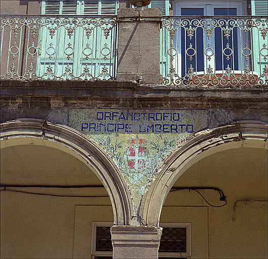 Détail de la façade : inscription et armes de Savoie en mosaïque au centre du portique.