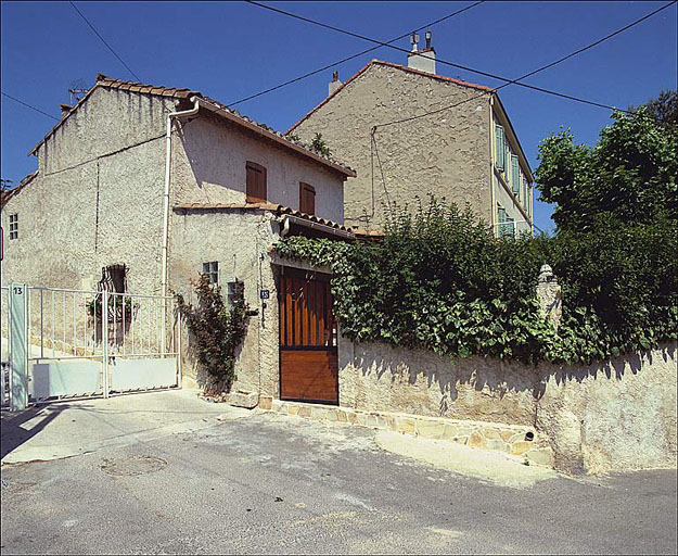 Vue générale de la maison et de son jardin clos, depuis la traverse. ; Vue générale de la maison et de son jardin clos, depuis la traverse.