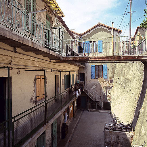 Vue générale de la partie nord : immeubles à logements des parcelles 62 et 63, cours anglaise et passerelle reliant la voie publique à la coursière du deuxième étage de la parcelle 63.