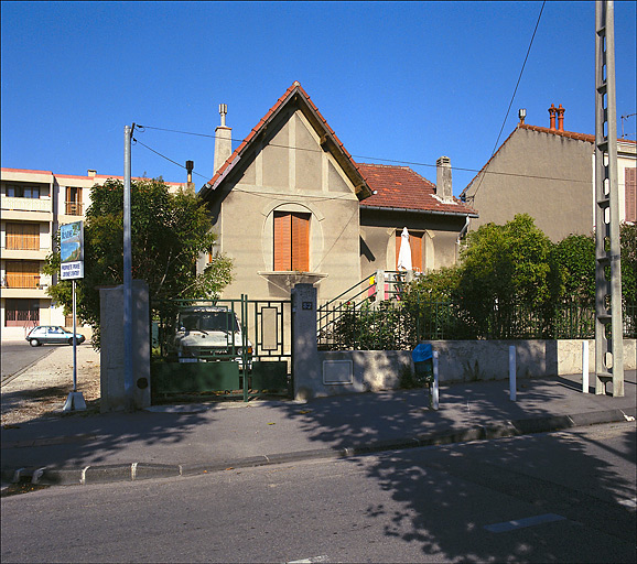 Vue générale de la façade, de la clôture et du jardin. ; Partie sud du lotissement, exemple de maison pavillonnaire en retrait sur rue avec clôture en mur-bahut et grille : parcelle I 89.