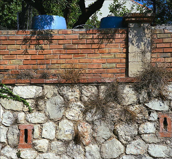 Partie sud du lotissement. Détail d'un mur de soutènement de jardin sur la rue Mariaud. Soubassement en appareil polygonal de calcaire, avec chantepleures en briques, partie haute formant garde-corps côté jardin : assises de briques et piles de mortier couronnées de briques.