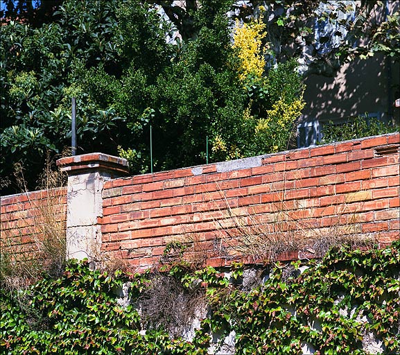 Partie sud du lotissement. Détail d'un mur de soutènement de jardin sur la rue Mariaud. Partie haute formant garde-corps côté jardin : assises de briques et piles de mortier couronnées de briques.