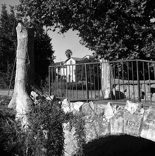 Faux tronc d'arbre en rocaille à l'entrée du pont.