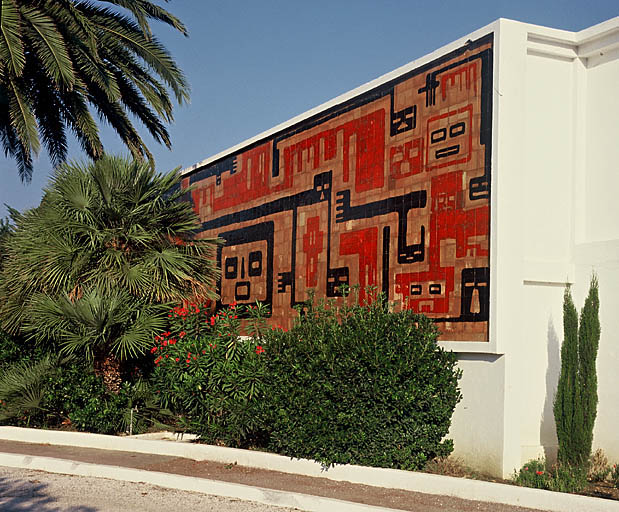 Garages situés à l'entrée de la résidence. Façade nord-ouest : décor de céramique.