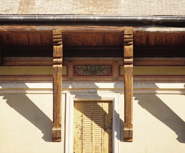 Détail de la frise en céramique du dernier étage et des aisseliers supportant le débord de toiture.