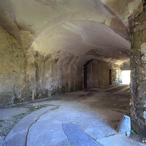 Passage d'entrée du fort, vu du débouché sur la cour, partie coudée, accès corridor, porte.