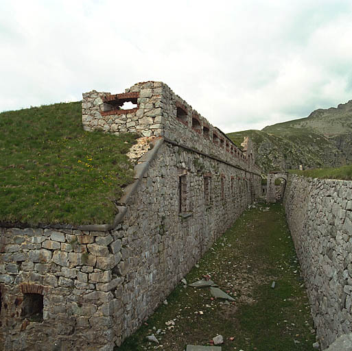 Enfilade du front de gorge et de son fossé, vu de l'angle nord-est ; fenêtre et parapet crénelé.