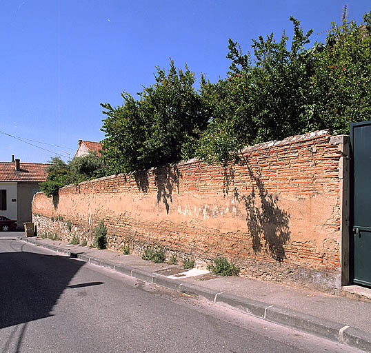 Partie sud du lotissement. Mur de clôture du jardin d'une villa, en maçonnerie de tuiles plates autrefois enduite, à l'angle de la rue Emile-Cavagni et de la rue Mariaud.
