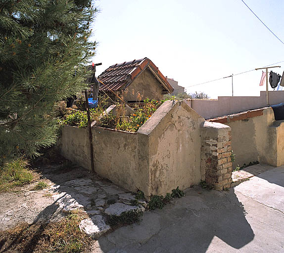 Lavoir commun parcelle D 110 et, à l'arrière-plan, latrines communes parcelle D 103.