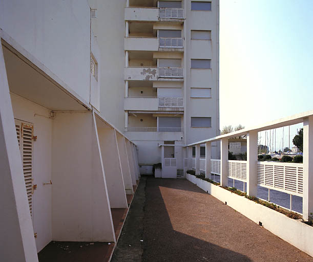 Immeuble à logements. Clôture isolant les cours des voies de circulation.