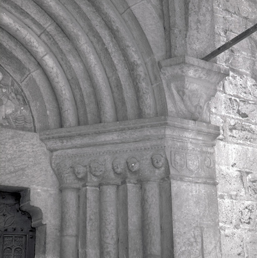 Façade sud. Porte droite. Partie supérieure de l'ébrasement droit : têtes.