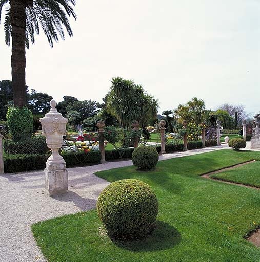 Jardin à la française: vue partielle du jardin surélevé, au nord, avec vase en pierre au premier plan et clôture au second plan, depuis le nord.