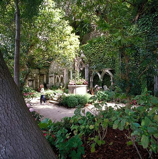 Jardin lapidaire: vue partielle depuis le sud, avec puits et arcades à l'arrière plan