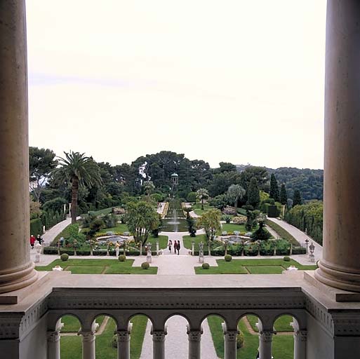 Vue d'ensemble du jardin à la française depuis la loggia située dans l'axe de la façade sud, avec balustrade au premier plan.