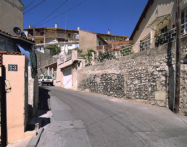 Vue prise depuis la montée Antoine-Castejon, en direction du nord. A l'arrière-plan, une partie de l'élévation postérieure, au sud, surplombe les façades de l'îlot.