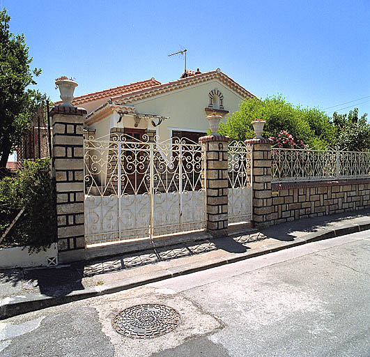 Maison, 19 boulevard Raymond-Fillat (parc N 18). Vue prise depuis la rue du mur-bahut de clôture, des portails et de la façade de la maison.