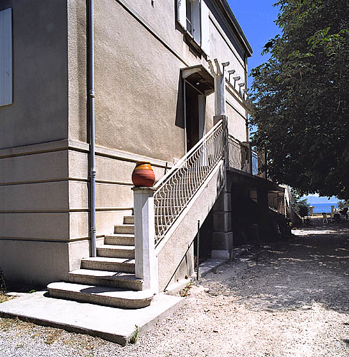 Vue biaise de l'élévation latérale avec l'escalier de distribution extérieur donnant accès à la port d'entrée.