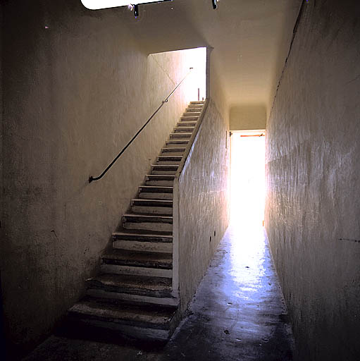 Vue intérieure couloir traversant donnant accès à la cour en fond de parcelle. A gauche, l'escalier desservant la coursière du premier étage.