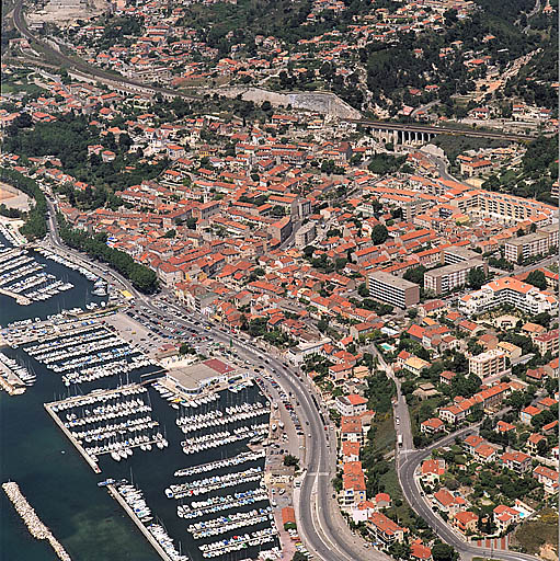 Vue aérienne de la zone centrale urbanisée, prise du sud en direction du nord-ouest. A gauche, le port et le chemin du Littoral. Au premier plan, les îlots de la Reconstruction de la Fontaine-des-Tuiles. A l'arrière-plan les voies ferrées et le viaduc du Marinier. ; Vue aérienne de la zone centrale urbanisée, prise du sud en direction du nord-ouest. A gauche, le port et le chemin du Littoral. Au premier plan, les îlots de la Reconstruction de la Fontaine-des-Tuiles. A l'arrière-plan les voies ferrées et le viaduc du Marinier.