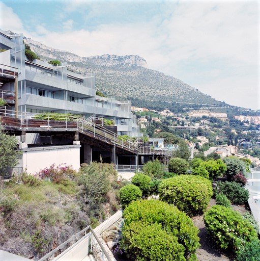 Centre de loisirs Pierre et Vacances : vue partielle de la façade sud du bâtiment nord avec couverture en terrasse aménagée en jardin du bâtiment sud au premier plan, depuis l'ouest.