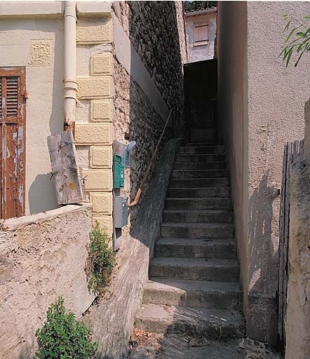 Escalier le long du pignon desservant la cour à l'arrière, en contre-haut.