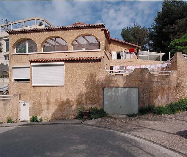 A droite garage en soubassement surmonté d'une terrasse, à gauche logis surmonté d'une loggia.