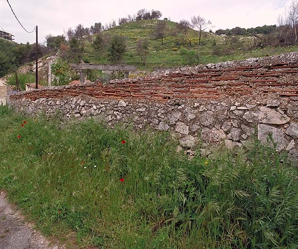 Détail d'un mur bordant le chemin des Poudrières : solin de moellons surmonté d'assises de tuiles plates posées à plat.