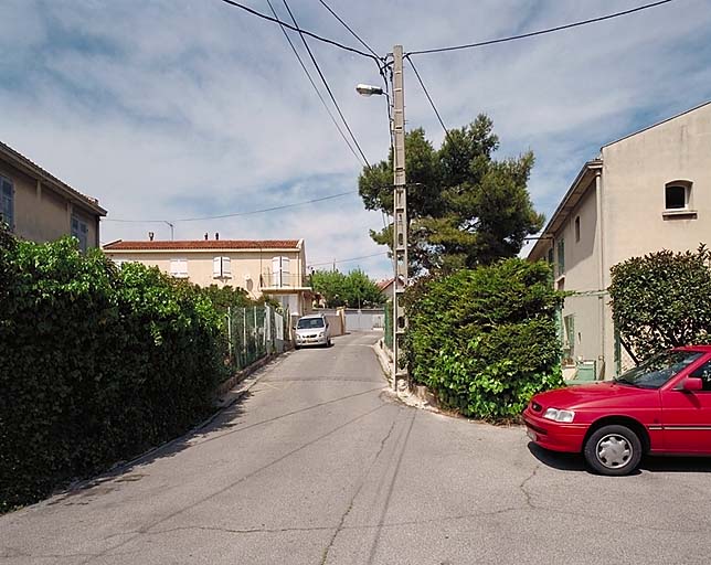 Vue en perspective de la rue principale de la cité ouvrière, vers le nord.