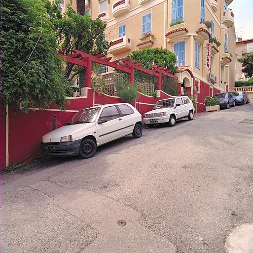 Vue partielle du mur de clôture du jardin surmonté d'une pergola, depuis le sud.