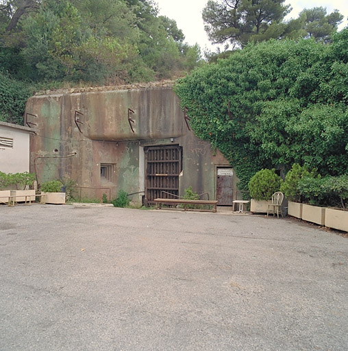 Façade du bloc d'entrée 1 avec restes de peinture de camouflage; à gauche créneau de flanquement des portes pour FM.