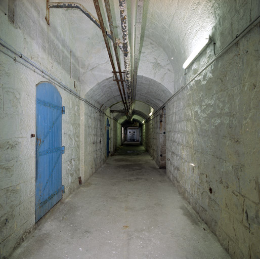 Enfilade de la galerie de distribution principale des souterrains prise du sud, dans le secteur du magasin à poudres (porte à droite).