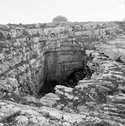 L'orifice oriental de la doline et la borie, vus du nord (l'escalierd'accès, aménagé dans le rocher, est visible, en bas à gauche). ; Cipières, les Baumes. L'orifice oriental de la doline et la borie, vus du nord (l'escalier d'accès, aménagé dans le rocher, est visible, en bas à gauche).