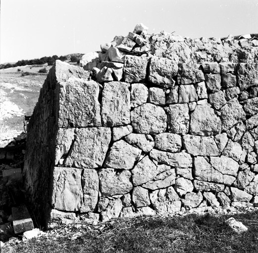 La bergerie de pierres-sèches, détail : l'angle nord du mur amont et sa surélévation maçonnée à la chaux, vus du nord-ouest.