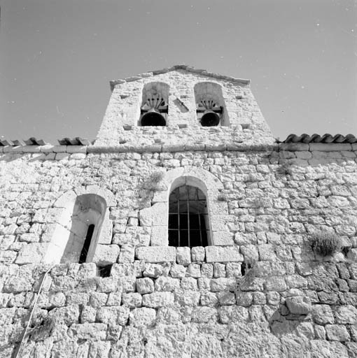 La façade antérieure, détail : la porte qui donnait accès à la constructin accolée à la façade (au centre), une fente d'éclairage (à sa gauche) et le clocher-mur, vus depuis le sud.