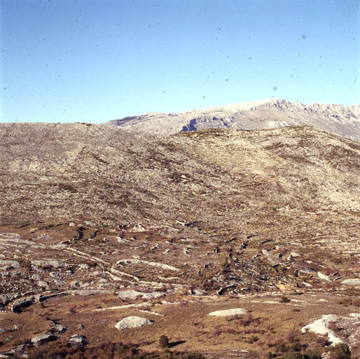 Extrémité nord du Plateau de Calern vue vers le nord-est : au premier plan le débouché oriental de La Combe, au second plan la crête (Le Serre) du Gros Pounch, en arrière plan (à droite) la montagne du Cheiron.