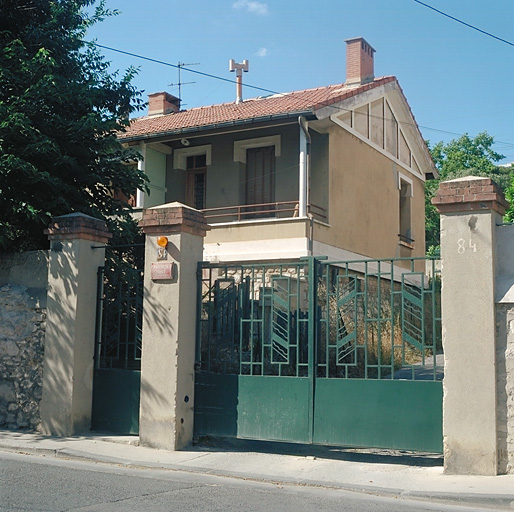 Cité ouvrière : Vue du portail et de la maison située à gauche de l'entrée.