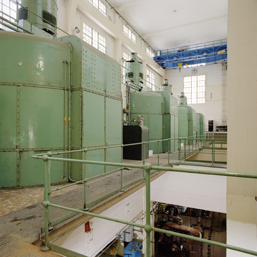 Les quatres alternateurs surmontés de leurs excitatrices. En bas, le niveau des turbines. Dans les parties hautes du hall des machines, un pont-roulant de 45 tonnes.