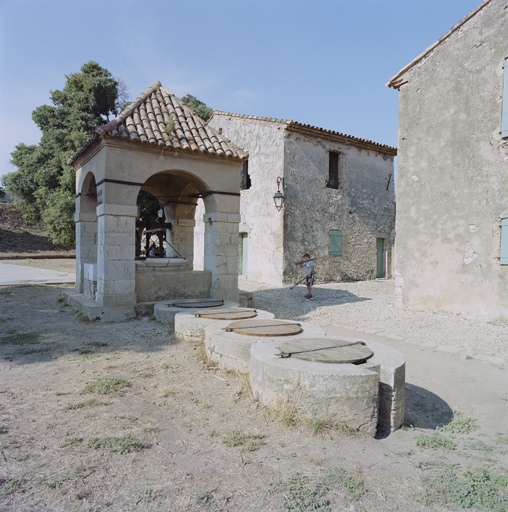 Le puits-citerne (i), avec son édicule de couvrement et ses citerneaux.