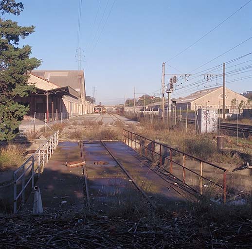 Vue vers le nord des voies ferrées. Au premier plan, le pont tournant. A l'est les roues. A l'ouest : au premier plan l'atelier de l'outillage et de la précision, puis la chaudronnerie de fer, le montage et l'atelier de réparation des freins des tenders. ; Vue vers le nord des voies ferrées. Au premier plan, le pont tournant. A l'est les roues. A l'ouest : au premier plan l'atelier de l'outillage et de la précision, puis la chaudronnerie de fer, le montage et l'atelier de réparation des freins des tenders.