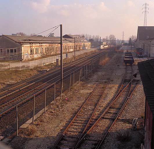 Vue vers le sud des voies ferrées. A l'est les roues, à l'ouest, au premier plan, l'atelier de réparation des freins des tenders, puis le montage, la chaudronnerie de fer et l'atelier de l'outillage et de la précision. ; Vue vers le sud des voies ferrées. A l'est les roues, à l'ouest, au premier plan, l'atelier de réparation des freins des tenders, puis le montage, la chaudronnerie de fer et l'atelier de l'outillage et de la précision.