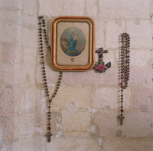 Ex-voto ancre en céramique et chapelets autour d'un tableau.