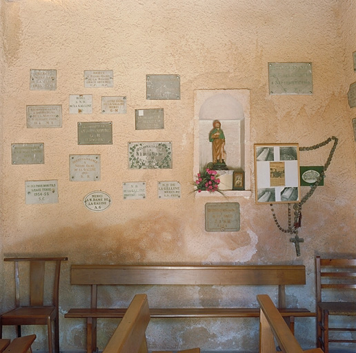 Mur nord : plaques de marbres ex-votos, niche avec la statue de Saint Roch et des chapelets.