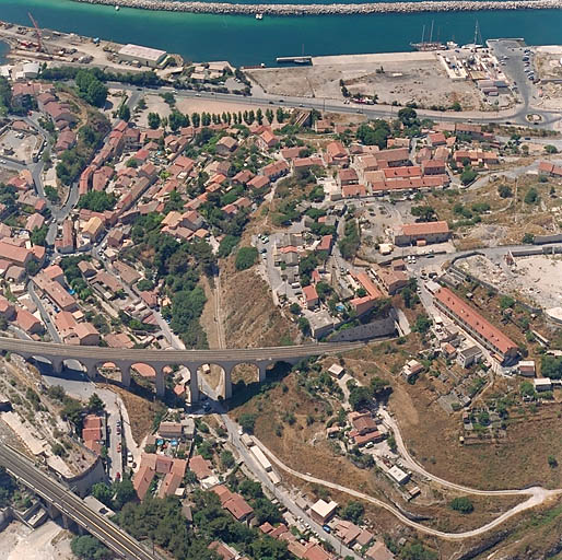 Vue aérienne d'ensemble prise du nord. Au premier plan, le vallon des Riaux, à droite la colline avec les cités ouvrières et les emplacement usiniers.