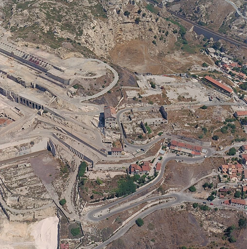 Vue aérienne prise du sud. La montée des usines avec quelques logements ouvriers et les vastes emprises au sol des usines démolies.